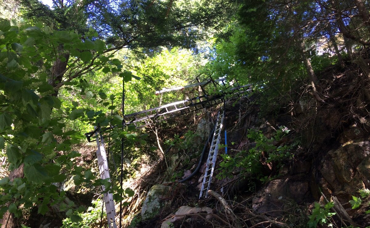 The lower 113 feet of track sat so high off the ground that we used the lift winch and our installation hoist to carry 20-foot sections of track to the end of the completed run. Once a section was in place, we unbolted it from the hoist, lowered it down, bolted it to the completed track, and set up ladders. That arrangement turned each new section into scaffolding for its own installation.