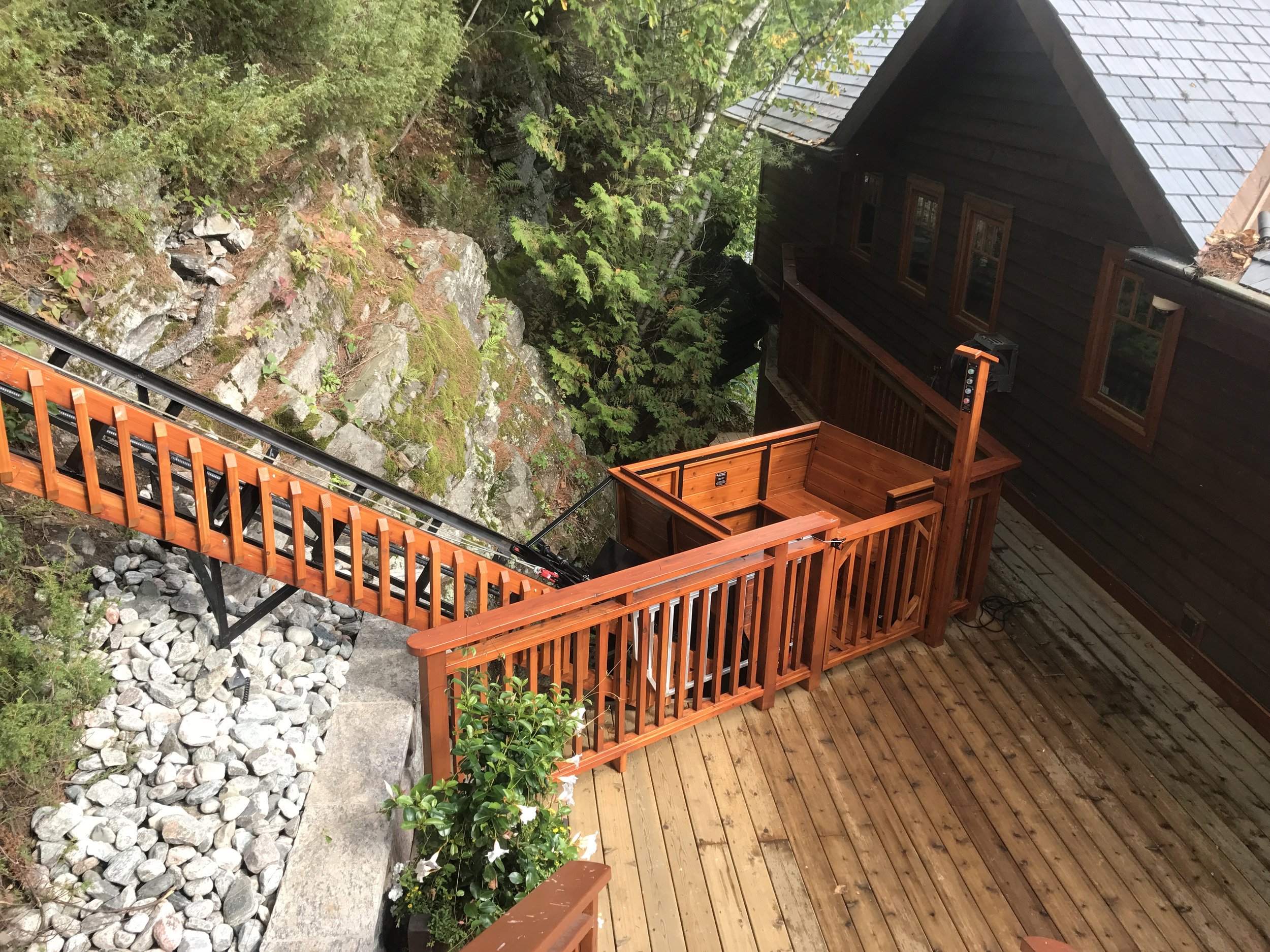 The lower station blends into the boathouse. The owner designed the cladding on the track to tie the lift line to the cottage, and Vision Contracting built it.