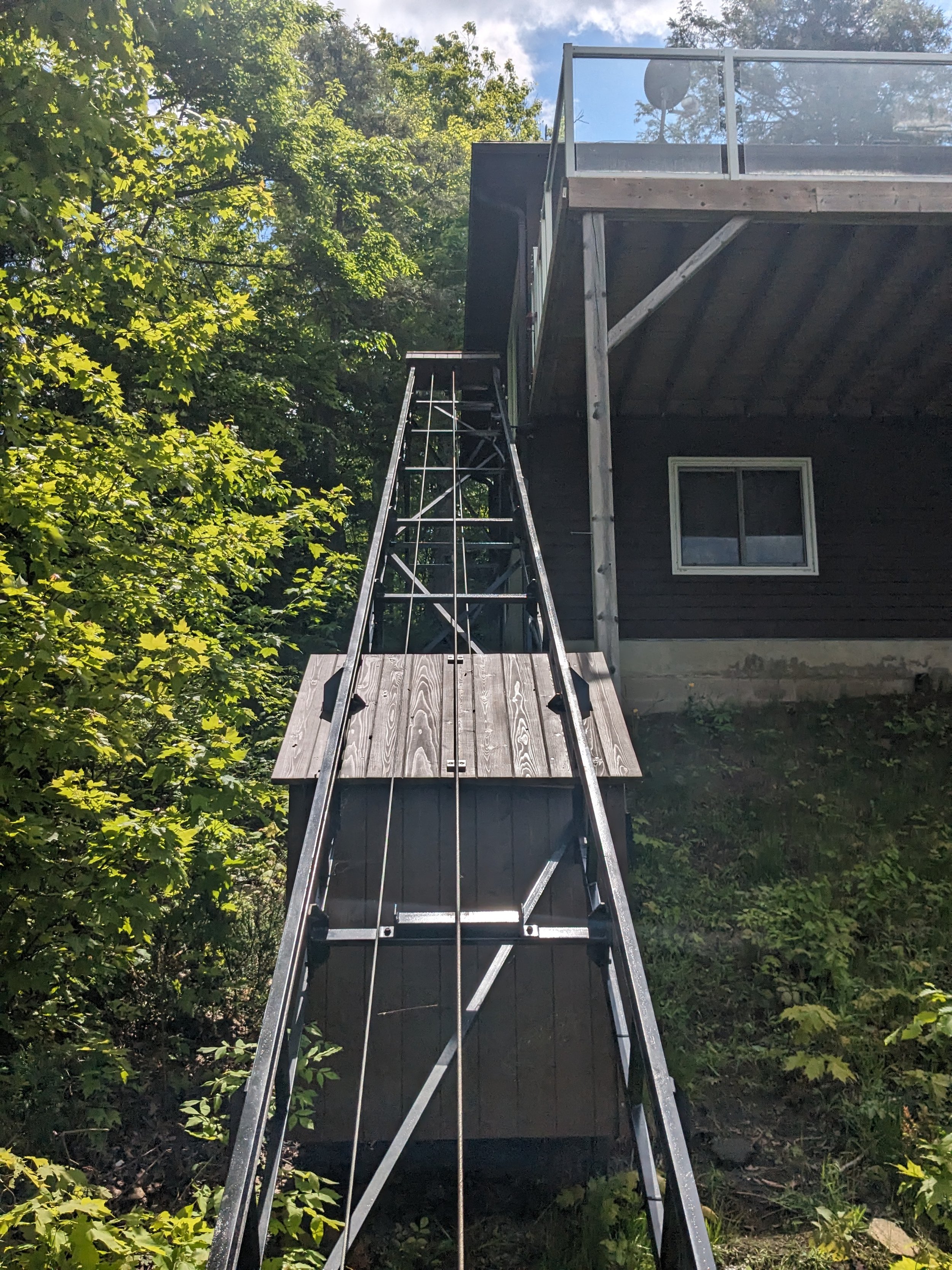 Because the upper station sits on the second storey of the cottage, we relocated the motor house and wiring panel down the hillside for easier access. That also minimizes the visual impact from the upper-station deck.