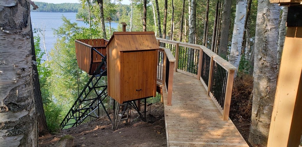 The height of the upper station required a walkway to connect the car to the lower level of the cottage. To the left of the lift lies an unused section of yard that will eventually be landscaped and planted. The walkway ties seamlessly into the old path that runs from the main deck of the cottage down to the stairs.