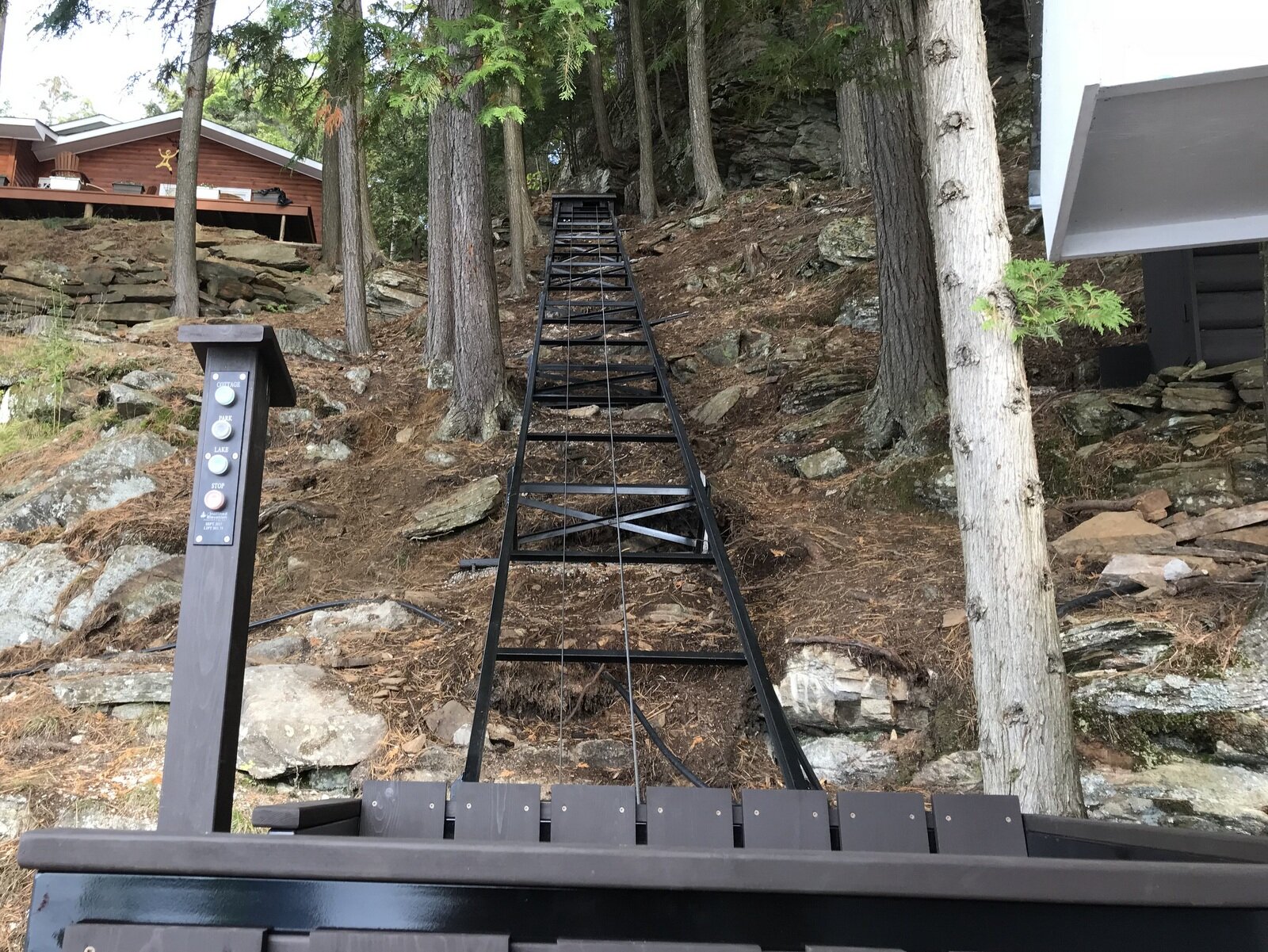 We kept the track and car as close to the hill as possible to preserve access to the storage shed door and the area behind the shed. The door is reachable even with the car in the lower station, and the PARK button moves the car completely out of the way while keeping it handy.