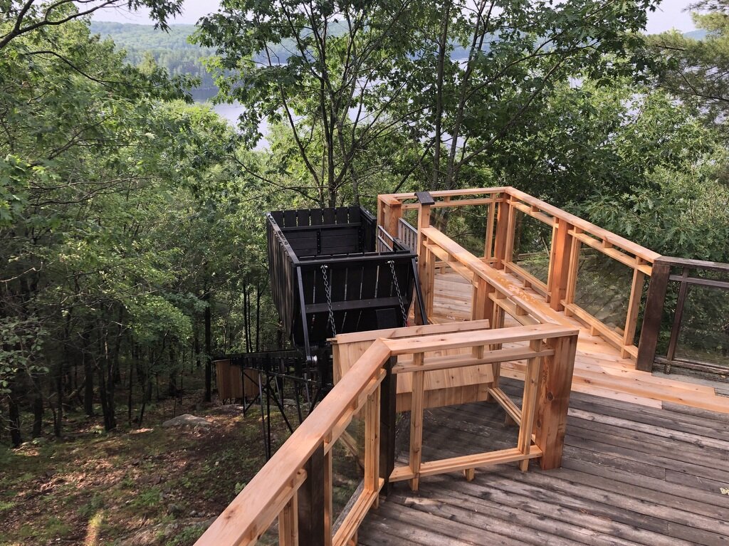 The upper station sits off one corner of the existing deck. The new platform, railings, and self-closing self-latching gate are integrated cleanly into the existing structures. We chose the track-to-deck intercept to minimize tree removal and to centre the new platform and rails on the existing railings. The station gate is interlocked with the lift for safety. Ronnie Hunt and his crew did a beautiful job on the deck.